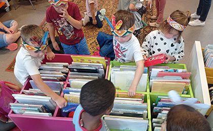 Les enfants regardent les livres à la médiathèque.