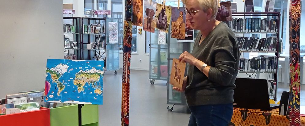 Dans l'interieur d'une bibliohèque, bibliothécaire montre une image.