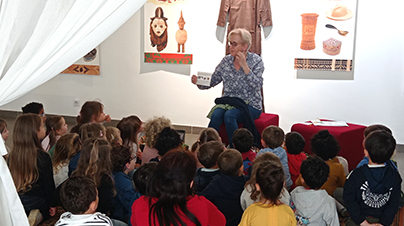 Les enfants assis partaire devant bibliothécaire dans la salle d'exposition