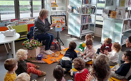 Bibliothécaire lit un livre aux enfants